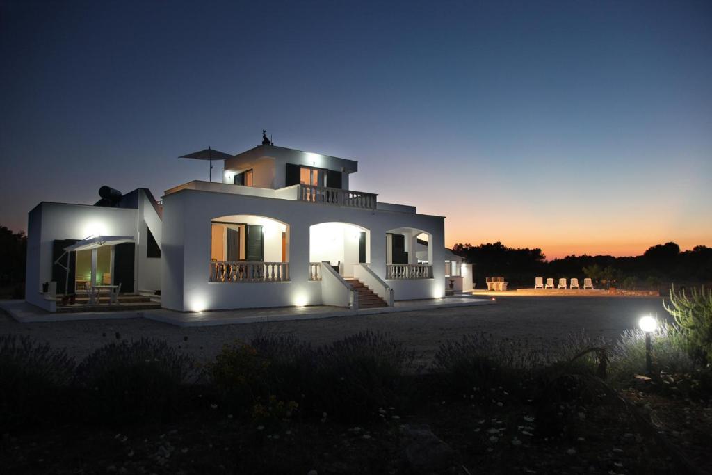 een groot wit huis met 's nachts verlichting bij Villa Giulia & Gaia - Guest House in Nardò
