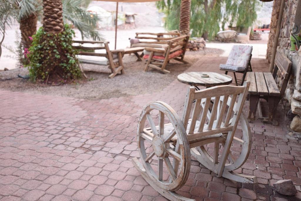 einer Gruppe von Bänken und Tischen und einem holzförmigen Rad in der Unterkunft Williams House in Eilat