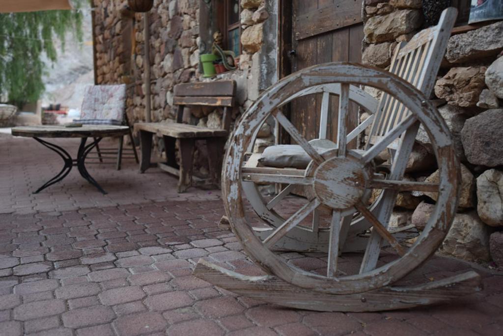 ein hölzernes Wagenrad neben einer Bank in der Unterkunft Williams House in Eilat