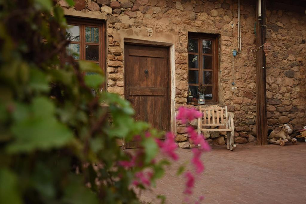un osito de peluche sentado al lado de un edificio con una puerta de madera en Williams House, en Eilat