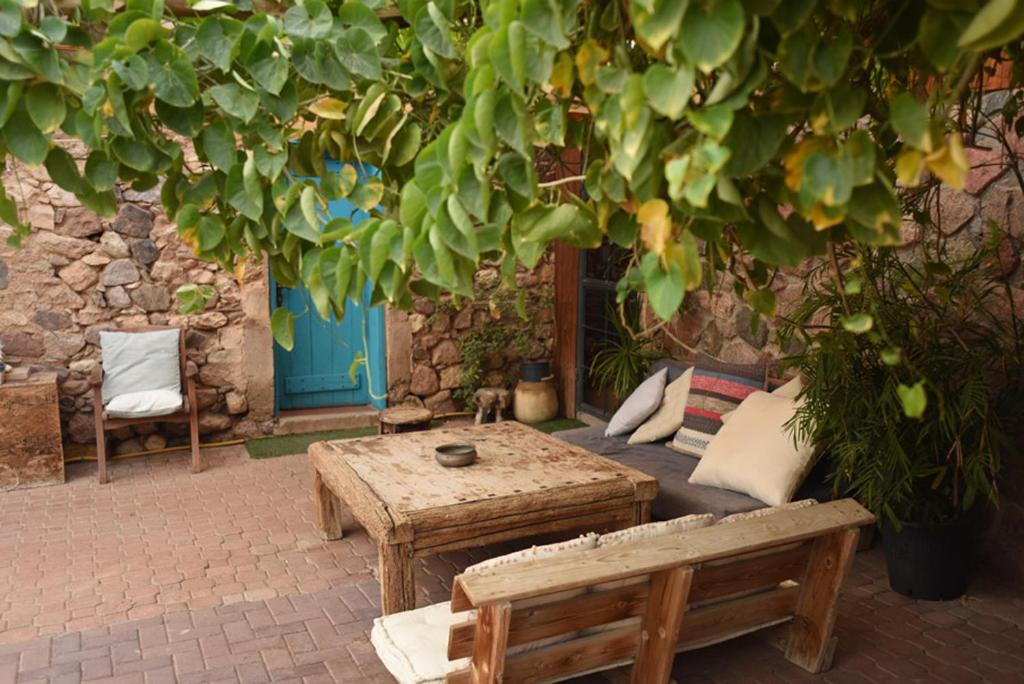 a table and a bench sitting under a tree at Williams House in Eilat
