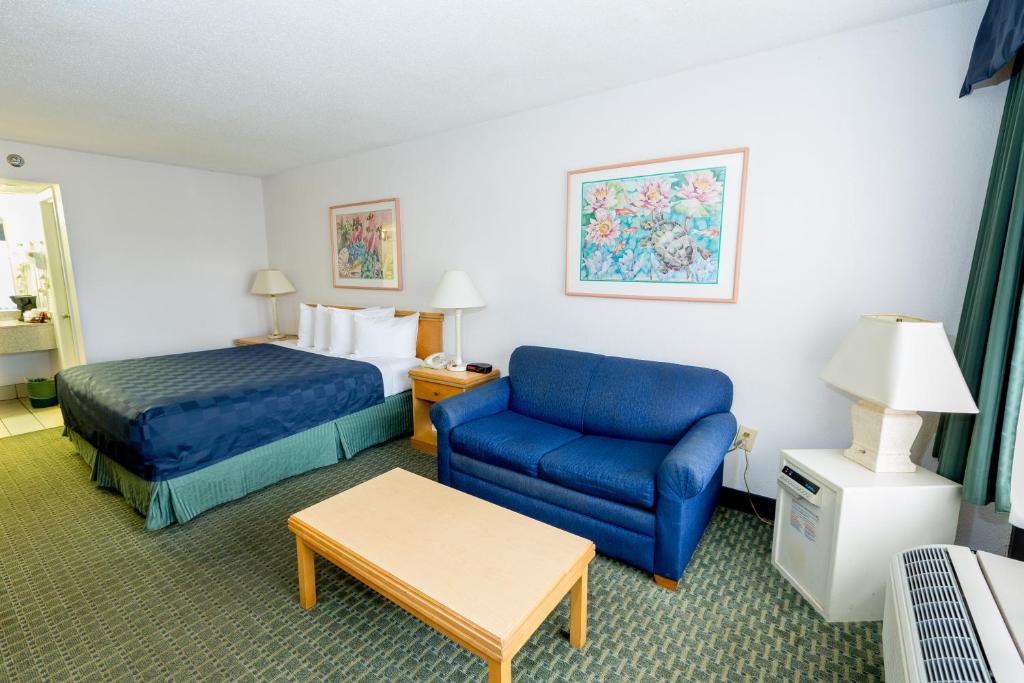 a hotel room with a bed and a blue couch at Maingate Lakeside Resort in Orlando