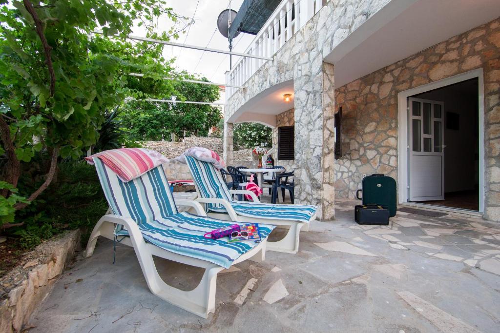 two chairs sitting on a patio with a table at The Sea House Apartments in Vis