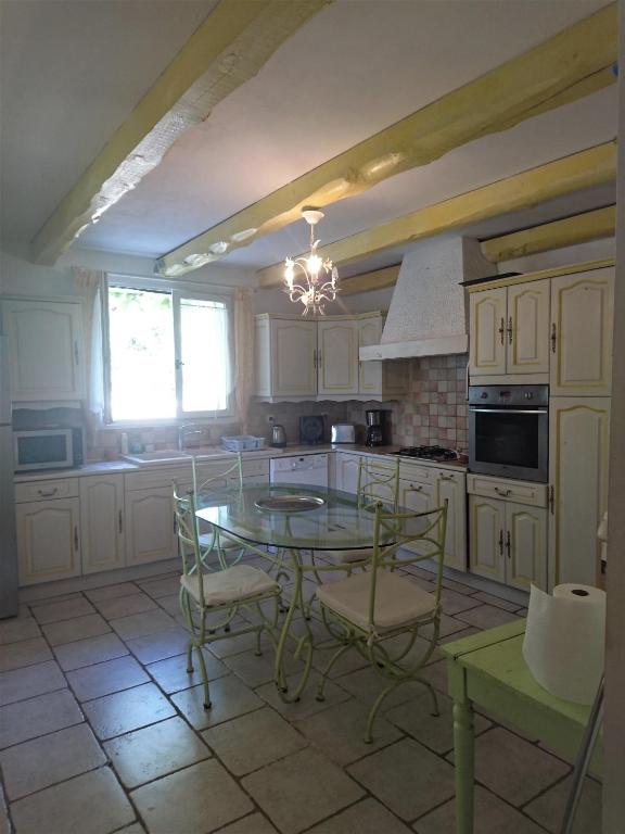 a kitchen with a table and chairs in a room at La Figalie in Saint Jean du Pin