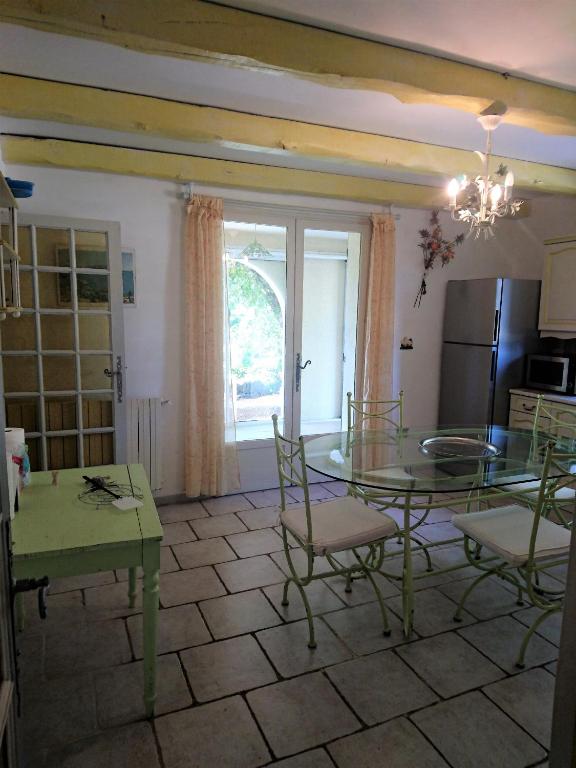 a dining room with a table and chairs and a kitchen at La Figalie in Saint Jean du Pin