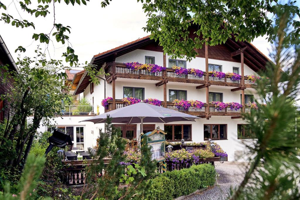 a building with a balcony with flowers on it at Das Reiners in Grafenau