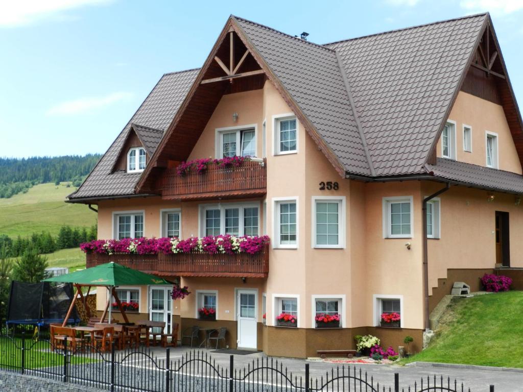 ein großes Haus mit Blumen auf den Balkonen in der Unterkunft Penzión Soňa in Ždiar