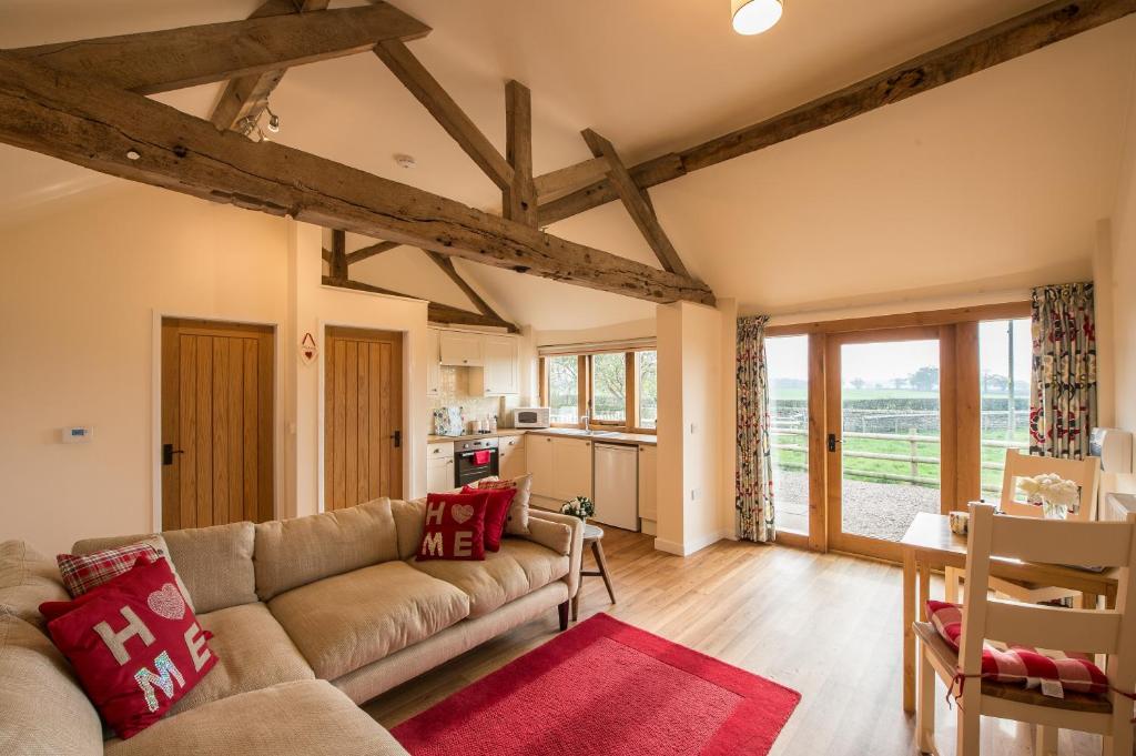 a living room with a couch and a kitchen at Paddock Cottage in Newport