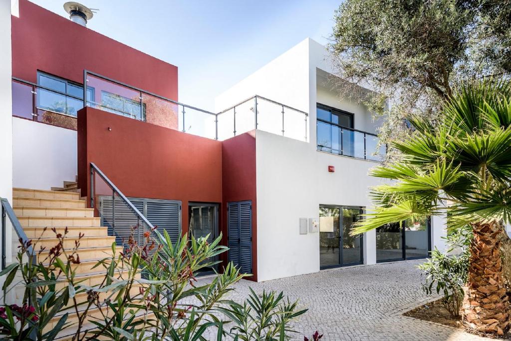 ein Haus mit einer roten und weißen Fassade in der Unterkunft Alvorférias Premium in Alvor
