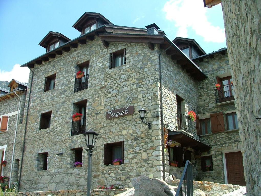 a large stone building with flowers on the windows at Hotel Areulo in Cerler