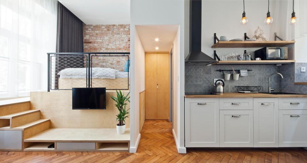 a kitchen with a staircase leading to a bedroom at Cosy Design Apartment II in Brno