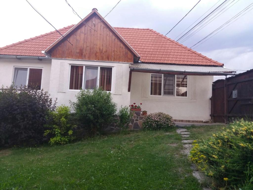 a white house with a red roof at Maksai Vendégház in Ocna de Sus