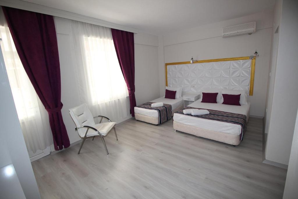 アーブシャ島にあるYürekli Apart Hotelのベッド、ソファ、椅子が備わる客室です。