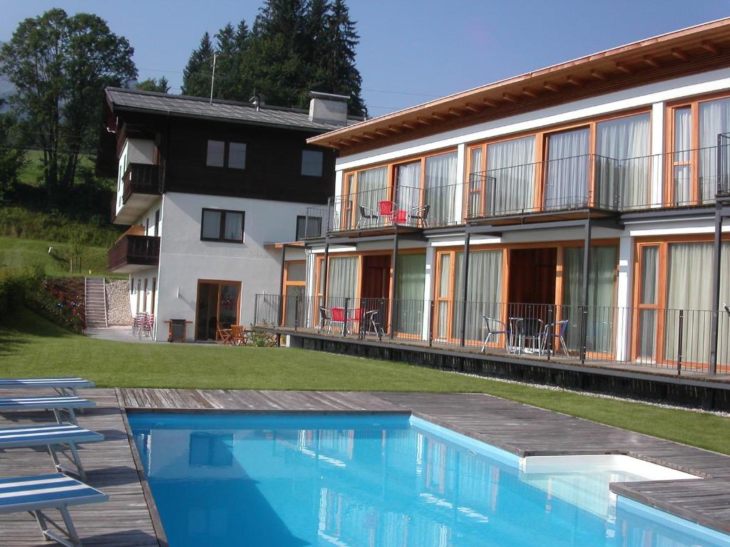 une maison avec une piscine à côté d'un bâtiment dans l'établissement Apartments Aeon, à St. Johann in Tirol