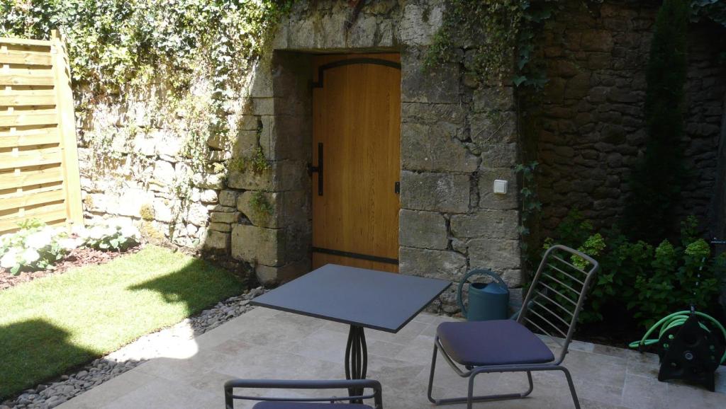 a table and two chairs in front of a door at Le Porche de Sarlat in Sarlat-la-Canéda