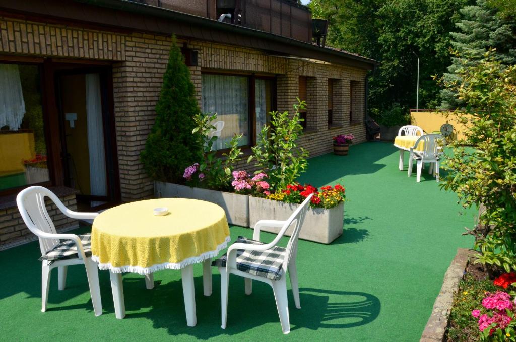 a patio with a table and chairs and flowers at Haus Scheuten Hotel in Duisburg