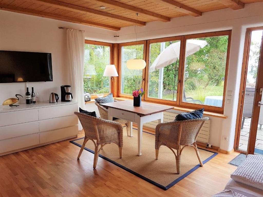 ein Esszimmer mit einem Tisch, Stühlen und Fenstern in der Unterkunft Apartment St. Leonhard in Überlingen