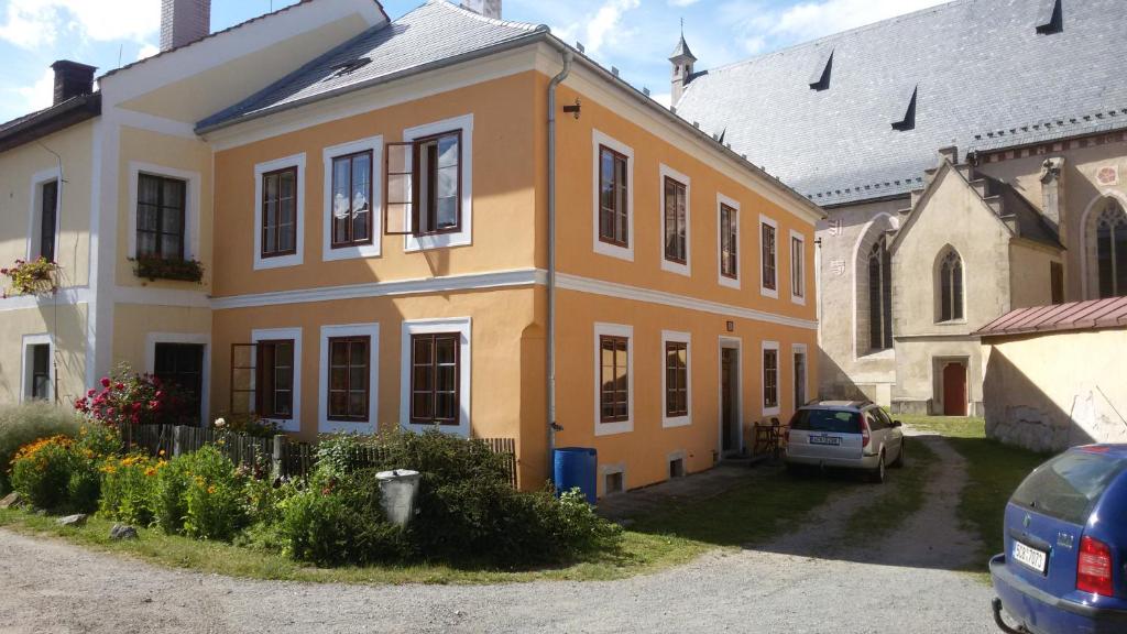 una casa amarilla con un coche aparcado delante de ella en Měšťanský Dům, en Rožmberk nad Vltavou