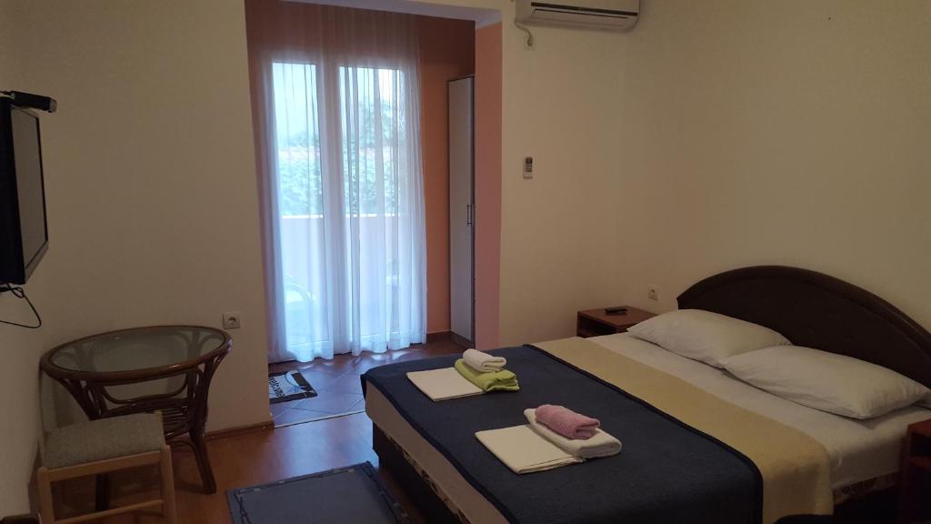 a bedroom with a bed with two towels on it at Sobe Jana in Budva