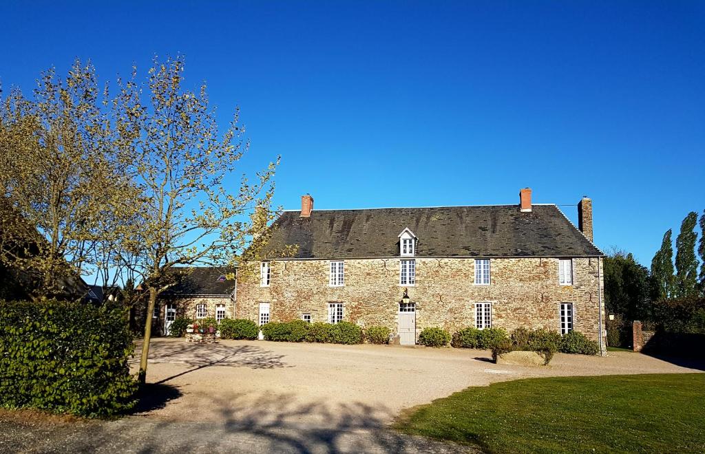 LitteauにあるLe Manoir de Herouvilleの青空を背景にした大きなレンガ造りの家