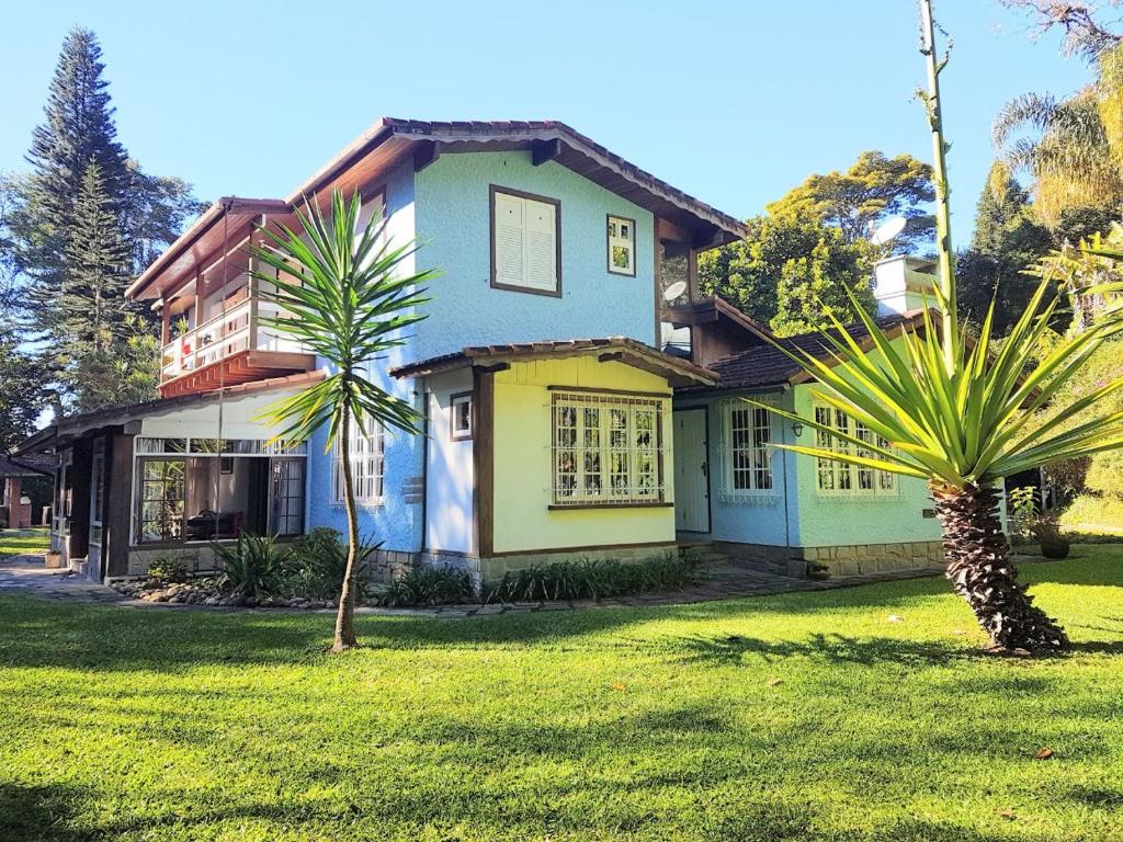 een huis met een palmboom ervoor bij Pousada Pinati in Teresópolis