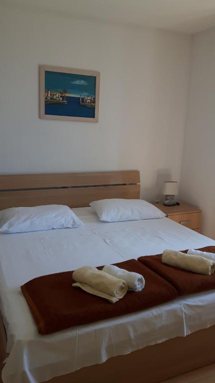 - un grand lit blanc avec 2 serviettes dans l'établissement Rooms Anđelka, à Bol