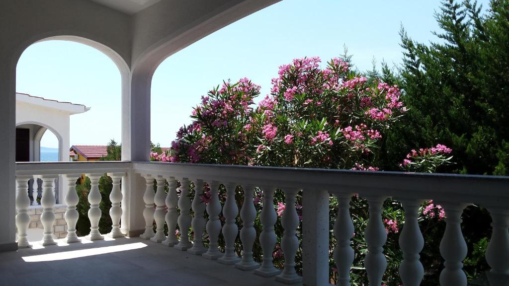 Una barandilla blanca en un balcón con flores rosas en Apartment Robić en Vir