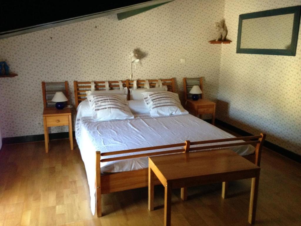 een slaapkamer met een bed met 2 nachtkastjes en 2 tafels bij Parc Lacoste in Saint-Marcet