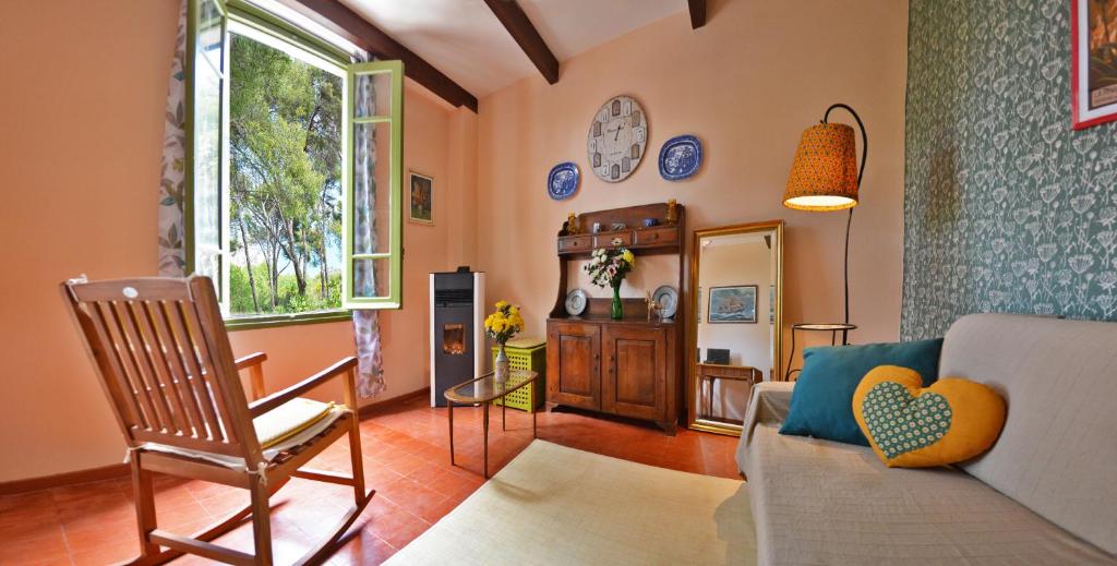 sala de estar con sofá y silla en Torre Alpicella - Holiday Home, en Diano Marina