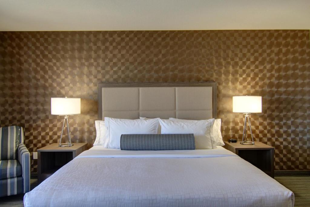 a bedroom with a large bed and two lamps at Canalta Kindersley in Kindersley