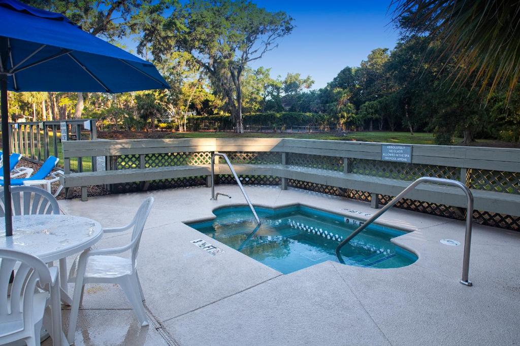 - une petite piscine avec une table et un parasol dans l'établissement Carolina Club by Spinnaker Resorts, à Île de Hilton-Head