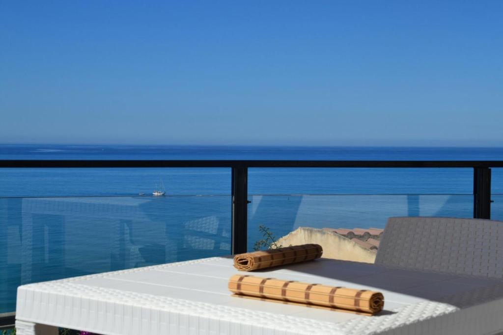 een tafel met een stoel en uitzicht op het water bij La Scogliera Turca in Realmonte