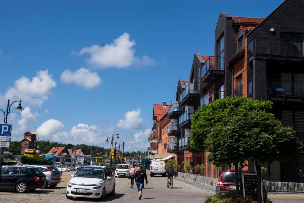 ruchliwa ulica miejska z samochodami i ludźmi idącymi ulicą w obiekcie Apartament Portowy Zakątek w Ustce