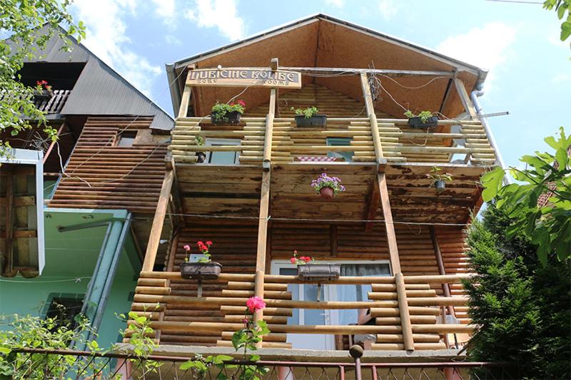 ein Gebäude mit Holztreppe und Topfpflanzen darauf in der Unterkunft Chalet Ljubicine kolibe in Golubinje