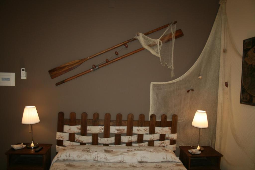 a bedroom with a bed with two night tables and two lamps at B&B Tifeo in Villafranca Tirrena