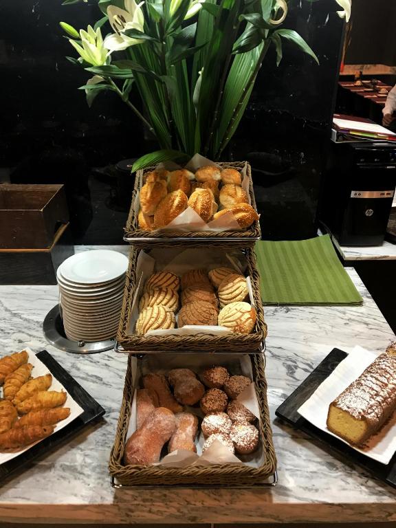 A pastry station displaying baskets of croissants, cookies and sweet breads.