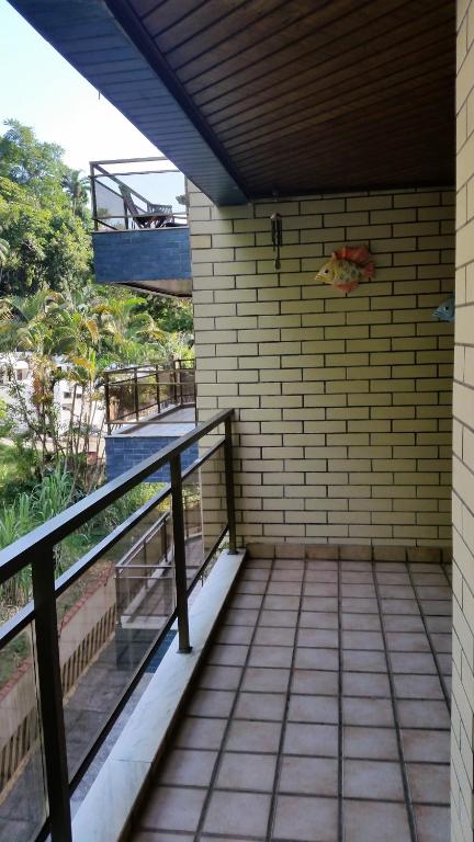 ein Balkon eines Hauses mit einer Pizza an der Wand in der Unterkunft Apartamento na Praia Grande em Ubatuba in Ubatuba