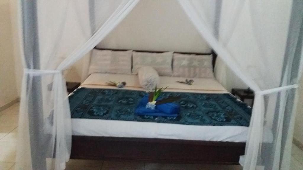 a bedroom with a bed with curtains and a bed sidx sidx sidx at Beten Enjung Home Stay&waroeng in Amed
