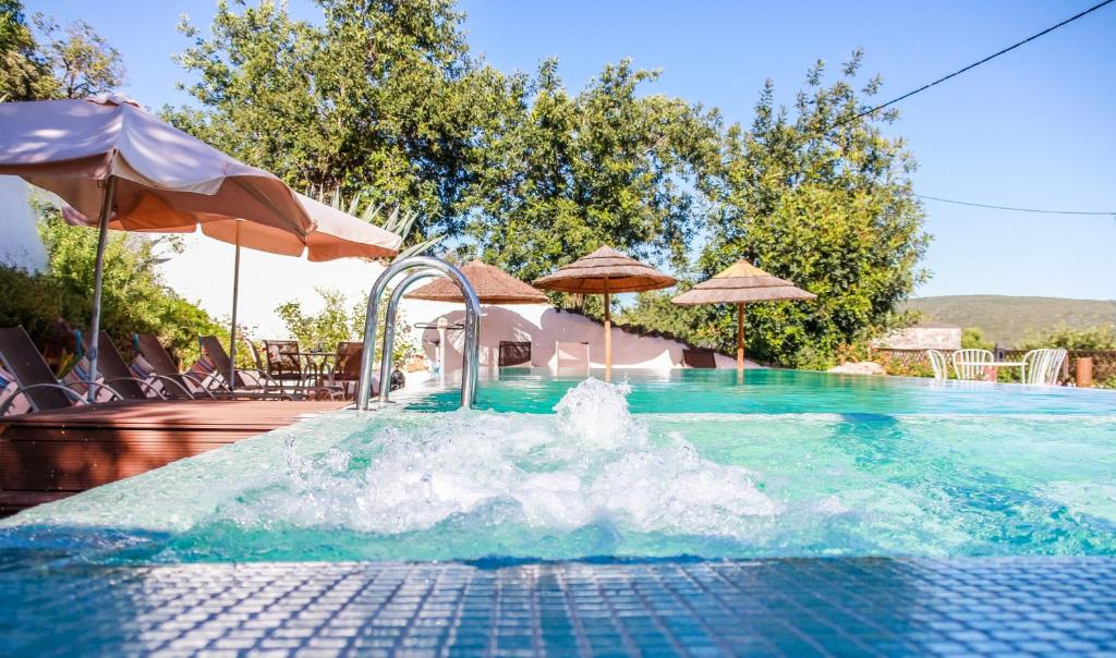 uma piscina com uma fonte de água num resort em Casa da Tita em Salir