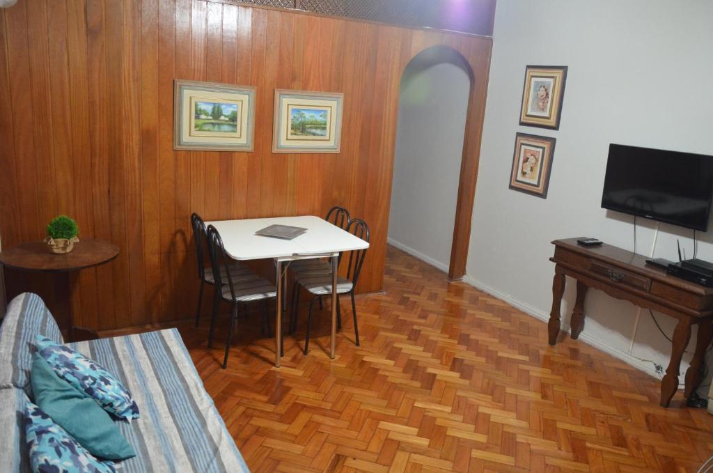 a living room with a table and a tv at Copacabana Etrusco Apartment in Rio de Janeiro