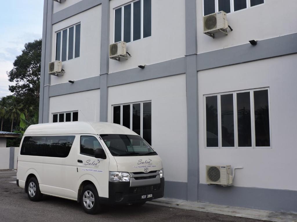 a white van parked in front of a building at Salsa Resort Langkawi By Casa Loma in Pantai Cenang