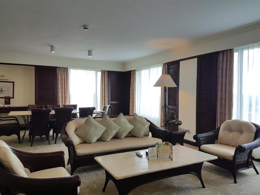 a living room with a couch and chairs and a table at Waterfront Airport Hotel and Casino in Mactan