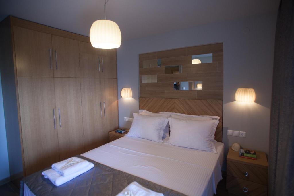 a bedroom with a bed with white sheets and pillows at Pallas Luxury Apartments in Ammouliani