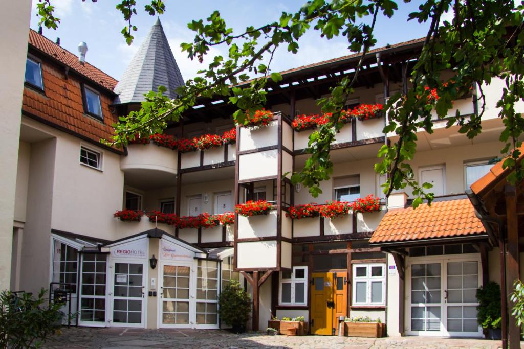 un edificio de apartamentos con flores en los balcones en REGIOHOTEL Wolmirstedter Hof Wolmirstedt en Wolmirstedt