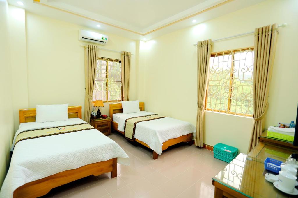 a bedroom with two beds and a window at Huy Hoan Hotel in Ha Giang