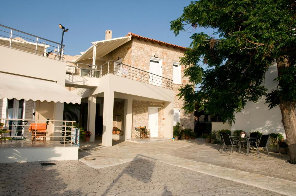 a white house with a patio and a tree at Iria Bay in Iria