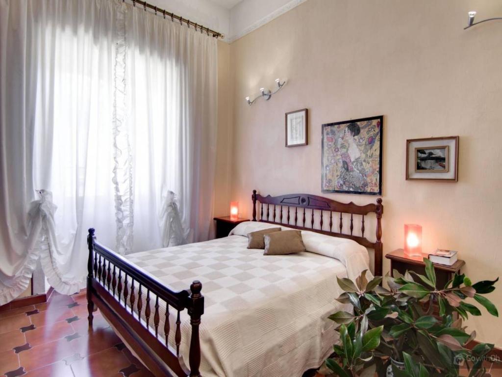 1 dormitorio con 1 cama grande y cortinas blancas en Oltre le Mura, en Roma
