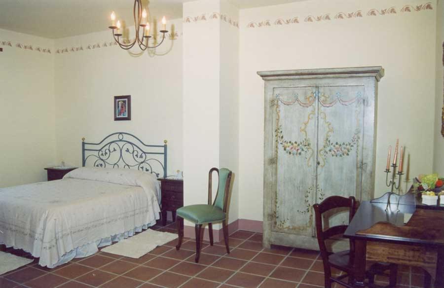 een slaapkamer met een bed, een bureau en een piano bij Agriturismo Martone in Rocca San Felice