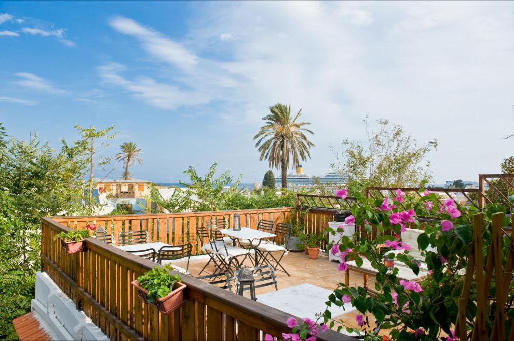 a balcony with tables and chairs and flowers at Kristina´s rooms in Rhodes Town