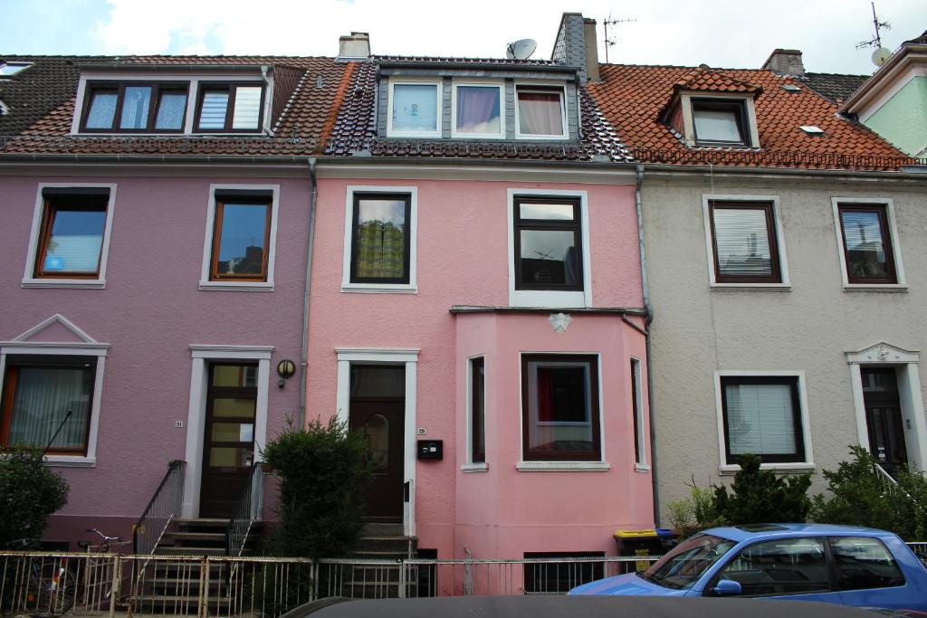 una fila de casas coloridas con un coche aparcado delante en Pension Isabel No2, en Bremen